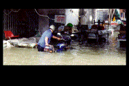 Man Pushing Motorcycle Through Water